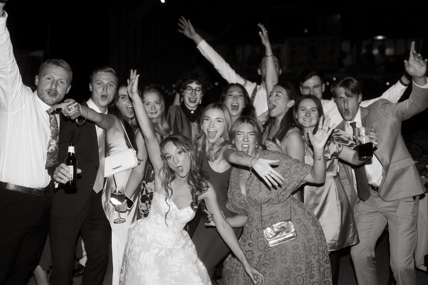 Large group of wedding guests dancing and celebrating on the dance floor.