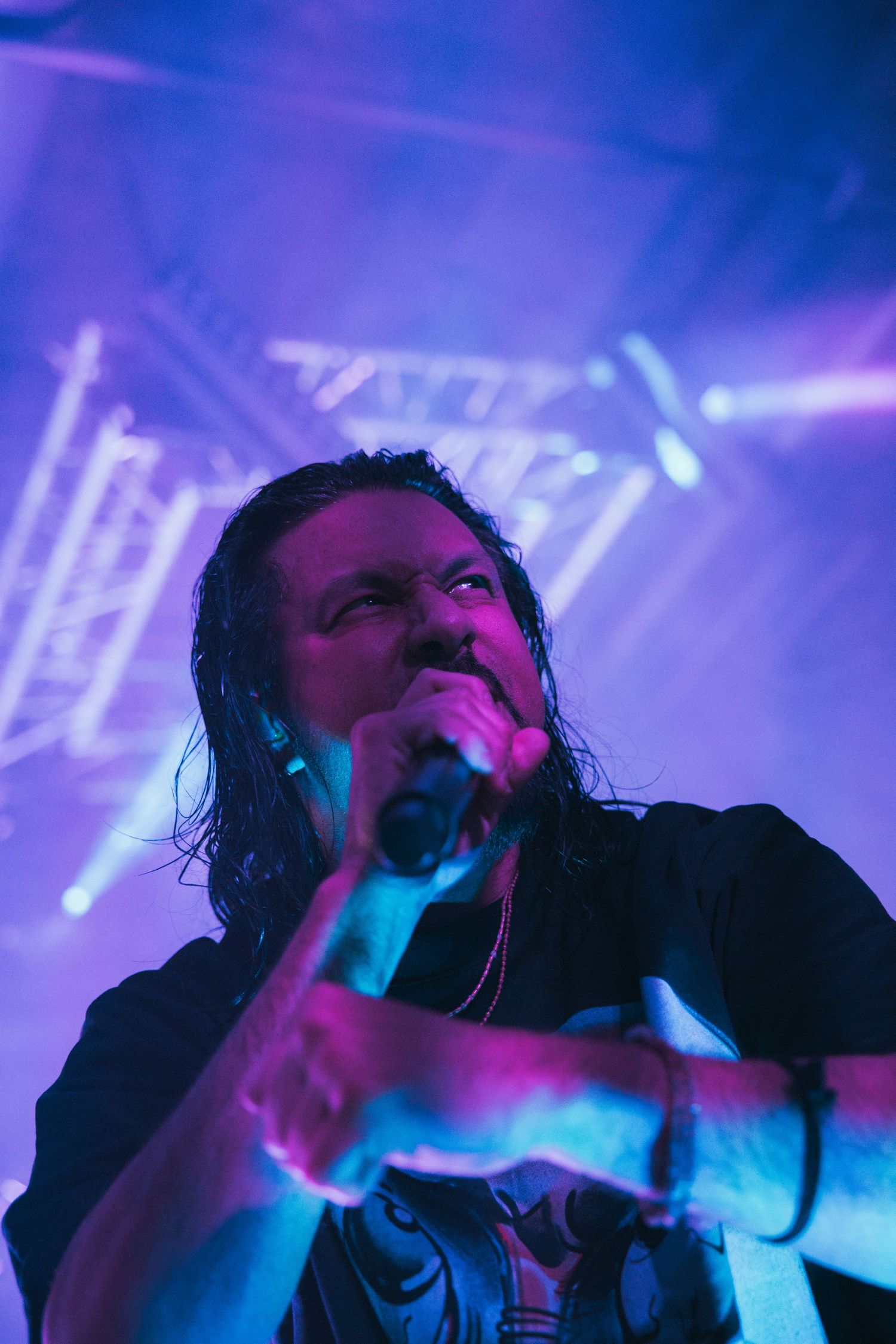 Live concert performance captured in vibrant blue and purple stage lighting shows an energetic singer performing.