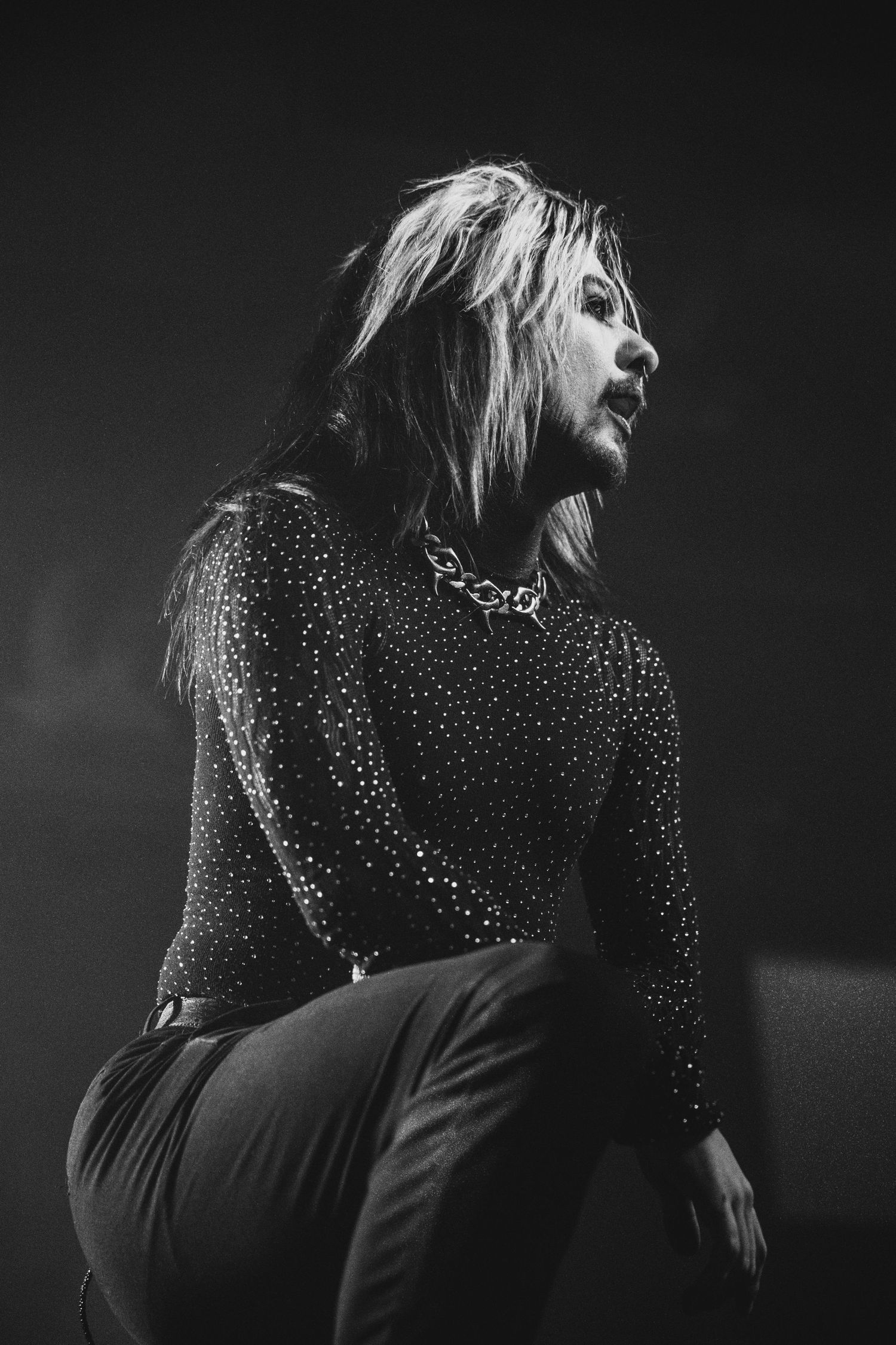 Dramatic black and white series of a performer in a polka dot top moving expressively against a dark background.