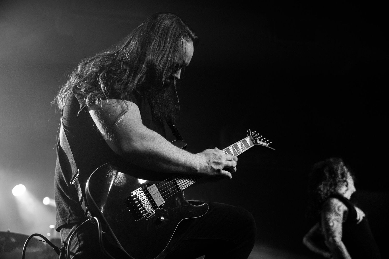 Moody black and white concert photos show musicians performing on stage in dramatic lighting.