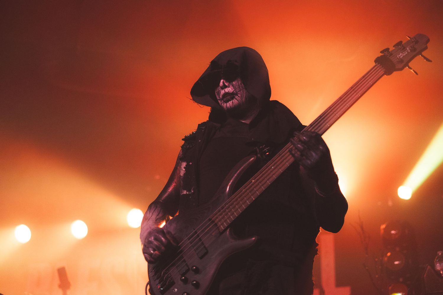 Heavy metal band performs on stage with dramatic red lighting and smoke effects creating an intense atmosphere.