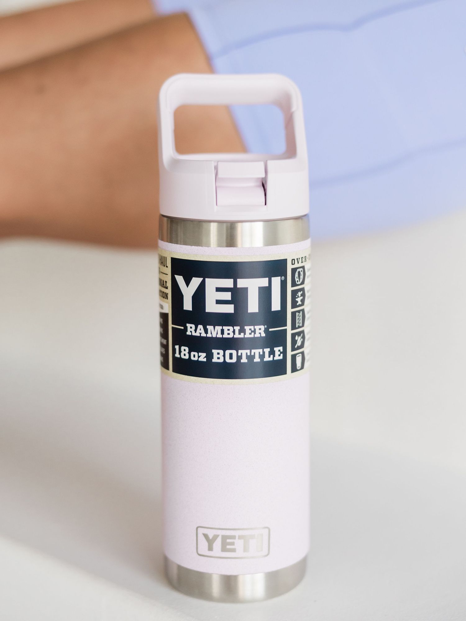 YETI Rambler 18oz insulated water bottle in light pink with straw cap lid on white surface.