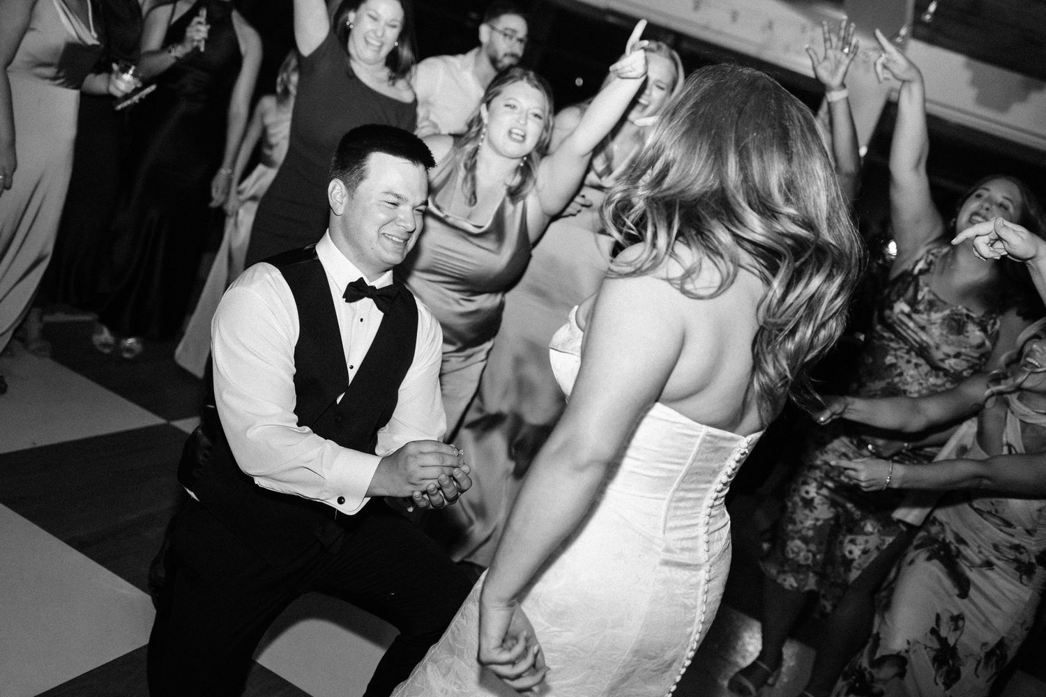 Black and white photos showing people dancing and celebrating at what appears to be a wedding reception.