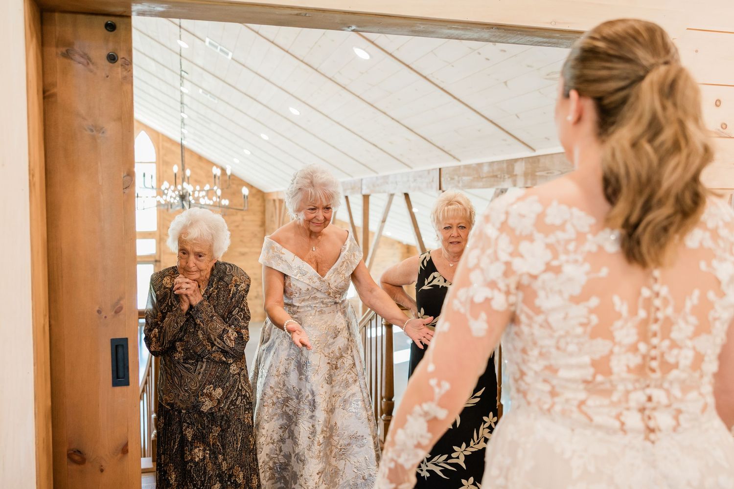 Wedding guests share an emotional moment of laughter and joy during an indoor celebration.