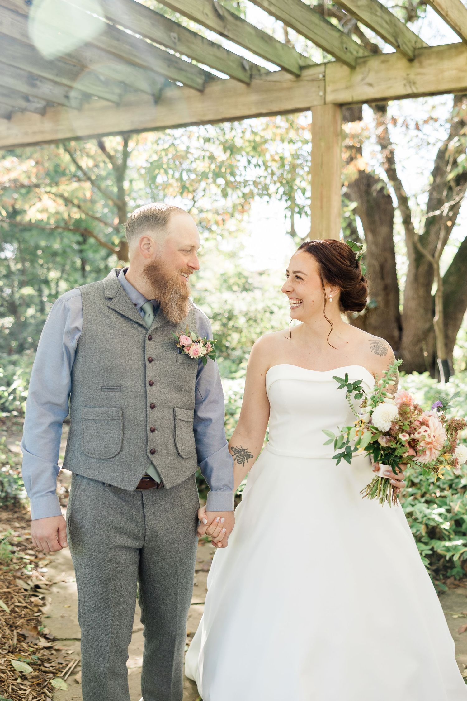 Romantic outdoor wedding photos of couple in grey suit and white dress sharing intimate moments in a sunlit garden setting.