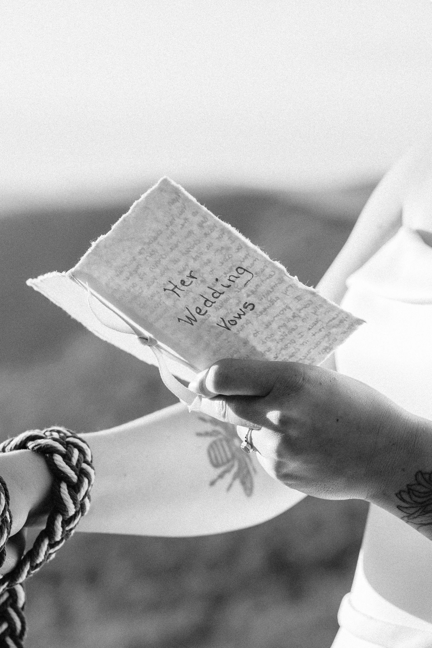 A black and white image shows hands exchanging handwritten notes or letters in a sequence.