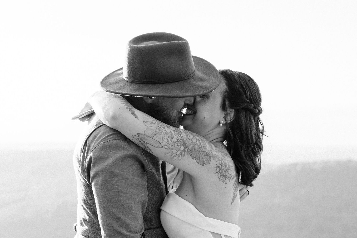 Intimate black and white wedding portrait with mountain scenery.