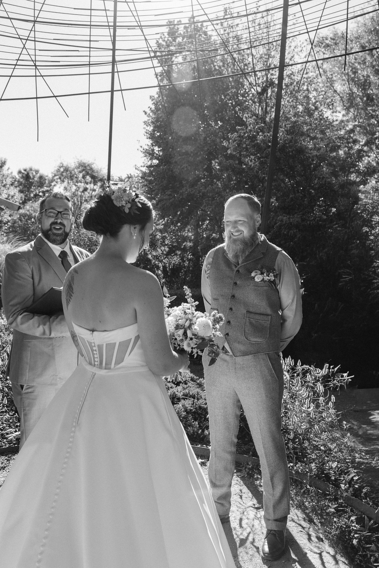 A series of black and white wedding photos showing joyful moments between a couple in formal attire outdoors.