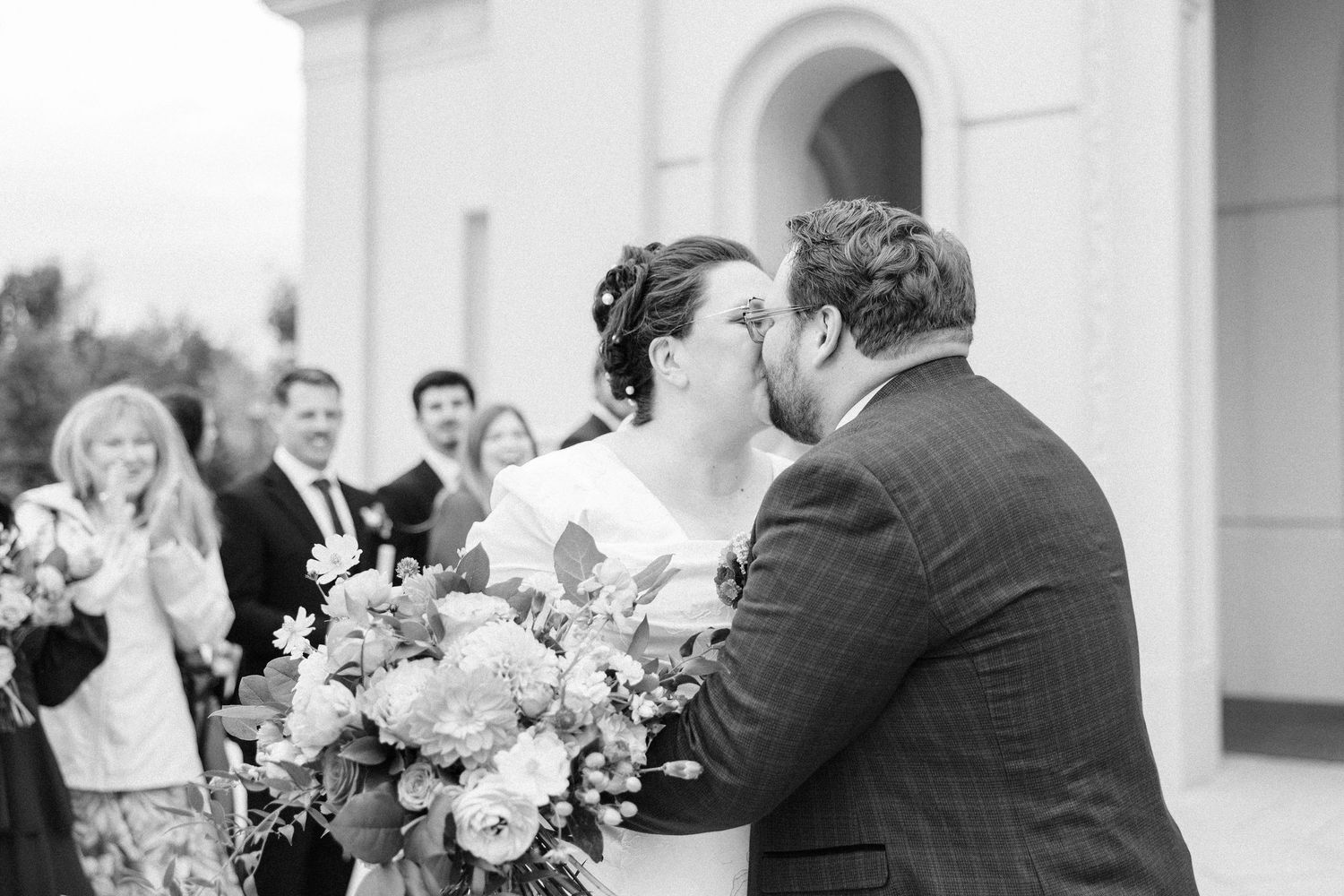 A series of black and white wedding photos showing romantic moments and floral bouquets.