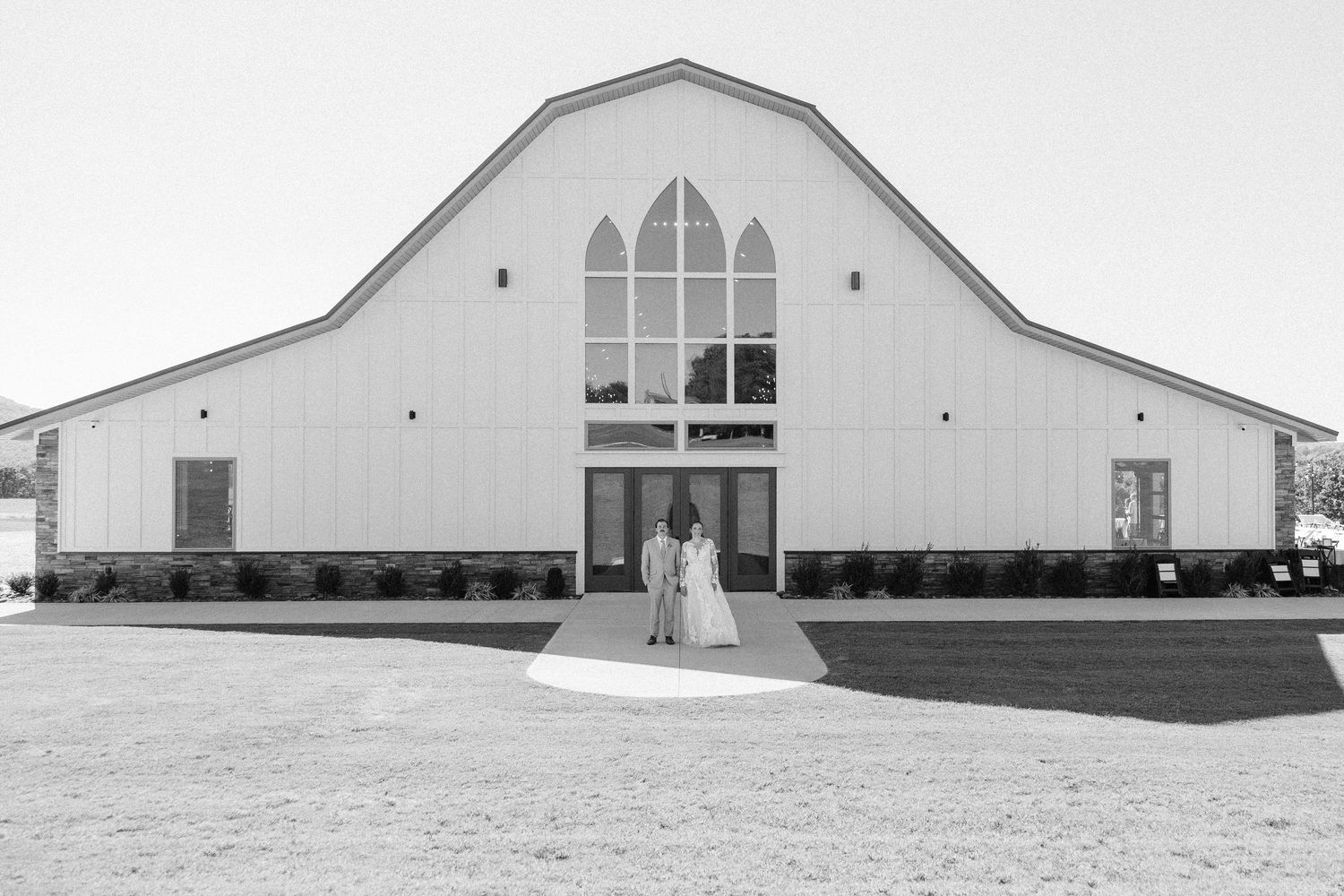 A minimalist architectural series showing different angles of a modern white barn structure.