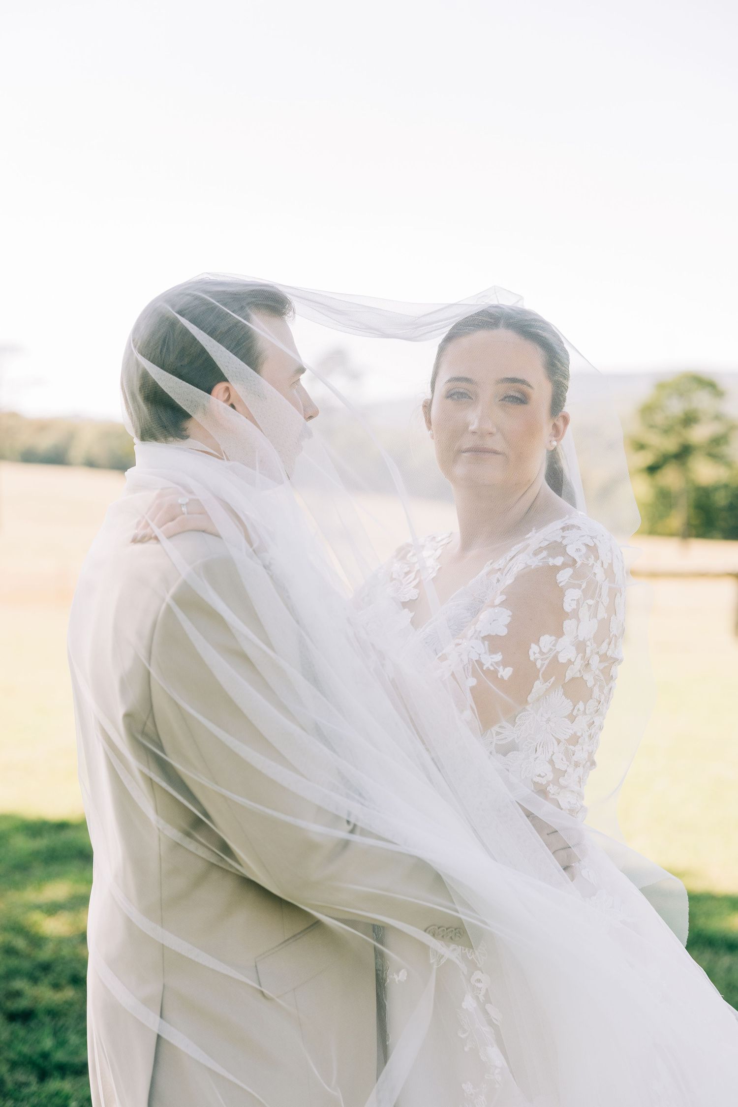 Ethereal bridal veil flowing in the wind against a bright outdoor backdrop.