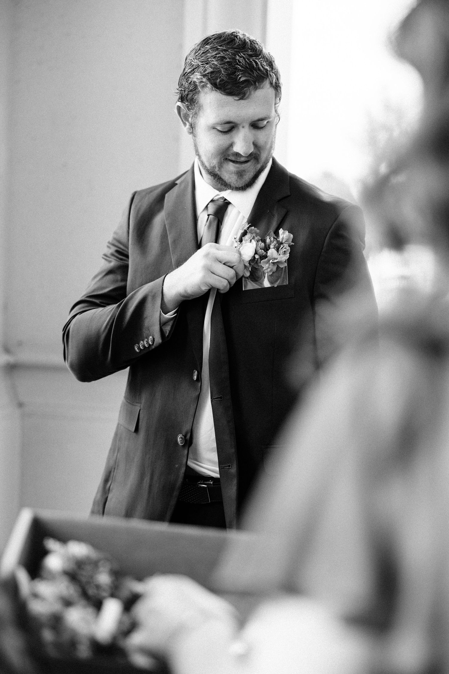 Wedding photographer in a black suit takes photos during a celebration.