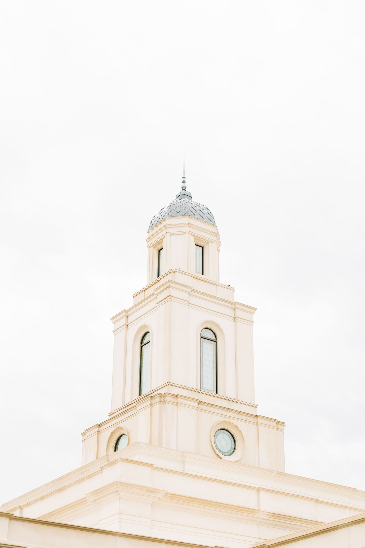 Elegant white church facade with domed tower and arched windows in classic architectural style.