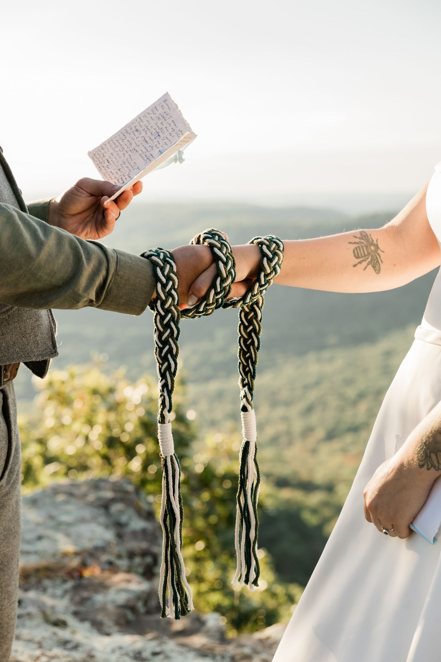 Four sequential images showing hands holding traditional handfasting cords against a mountain landscape background.