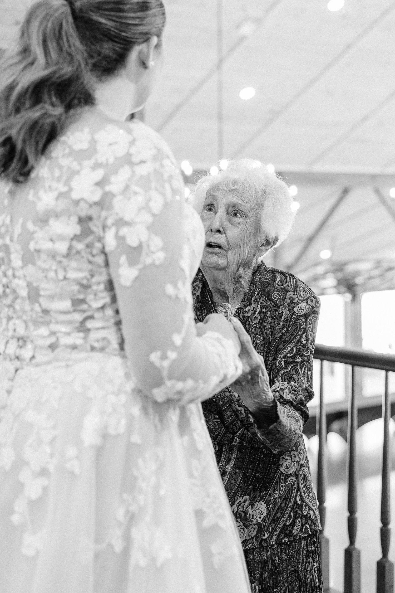 Emotional moment captured during a wedding ceremony with delicate lace dress details.