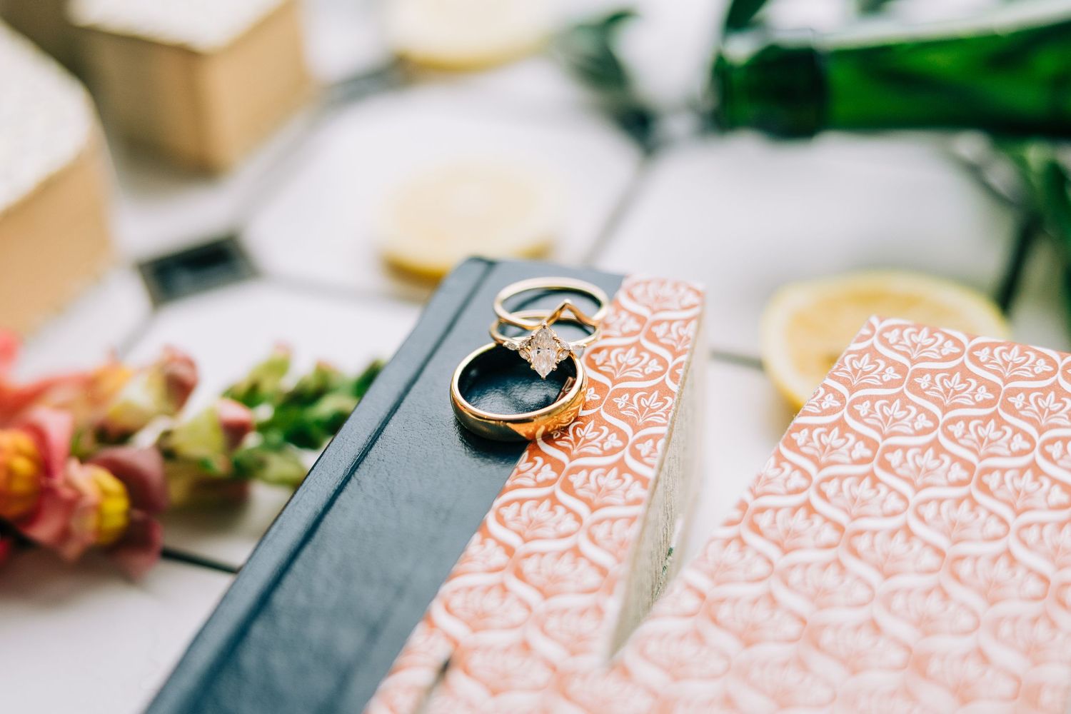 Wedding rings resting on a pink patterned book cover with floral decor.