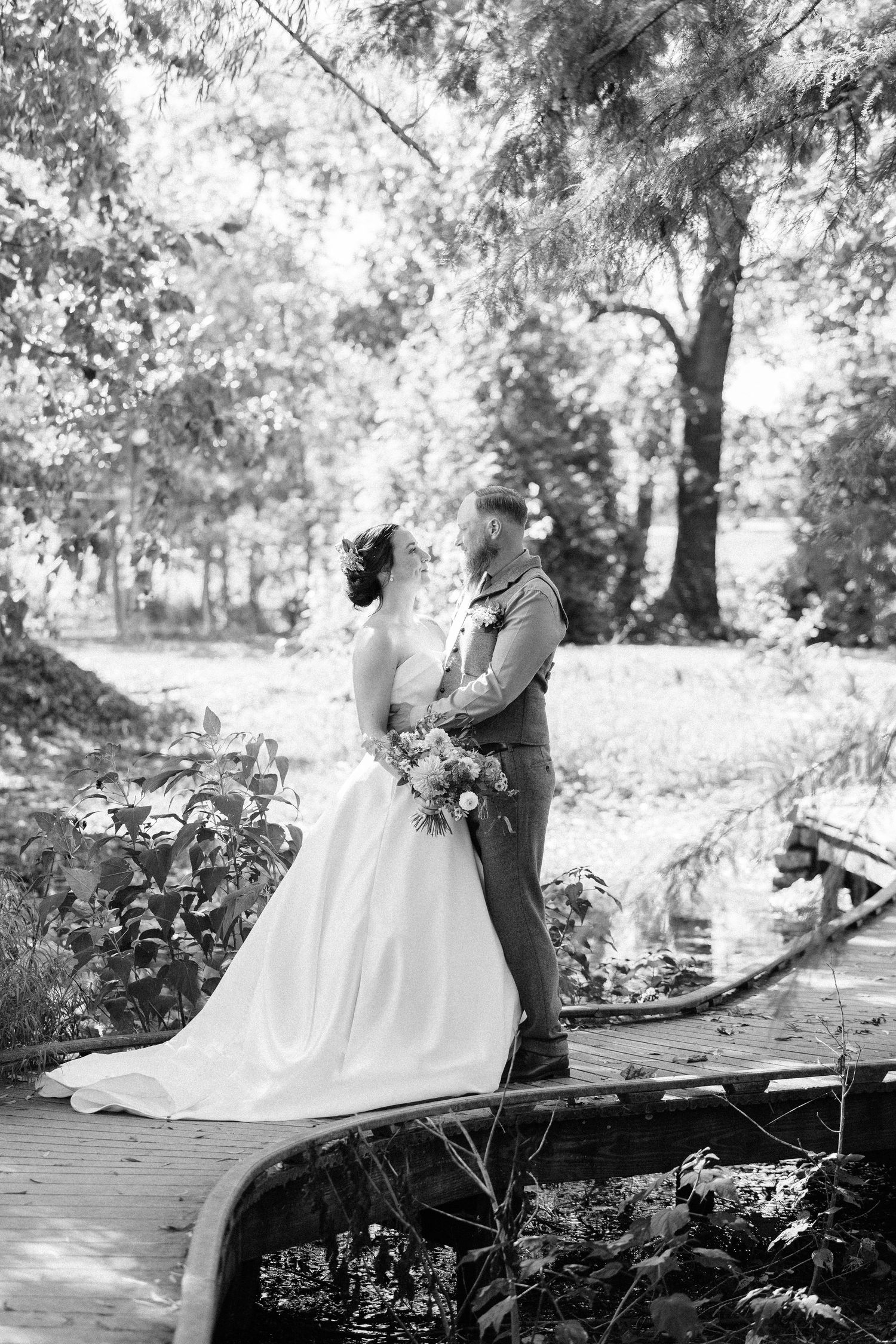 A romantic black and white wedding photo series showing a couple embracing in a garden setting.