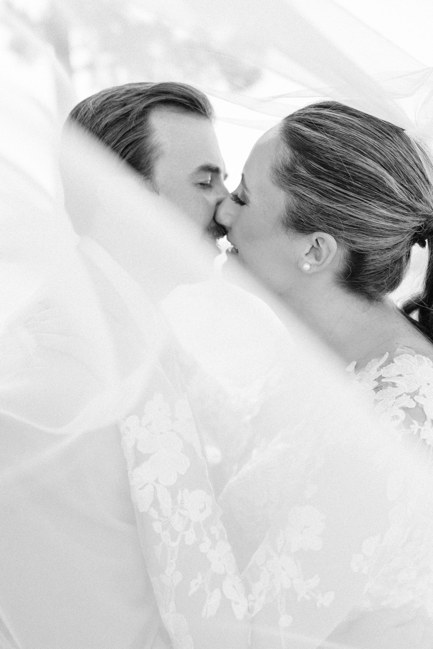 Artistic black and white close-up of a romantic wedding moment.