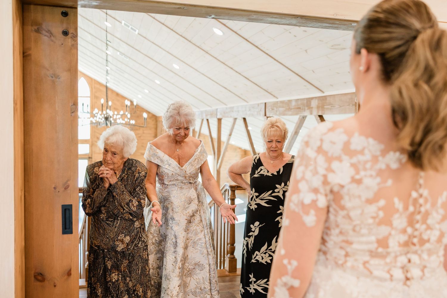 Wedding guests share an emotional moment of laughter and joy during an indoor celebration.