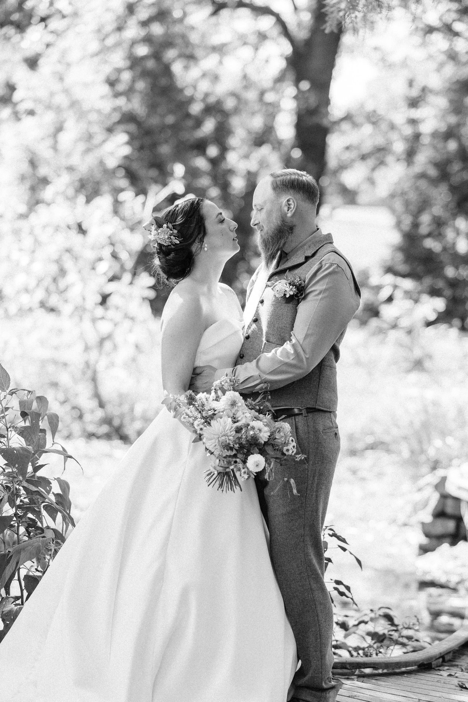 Black and white romantic wedding photos show couple sharing intimate moments in an outdoor garden setting.