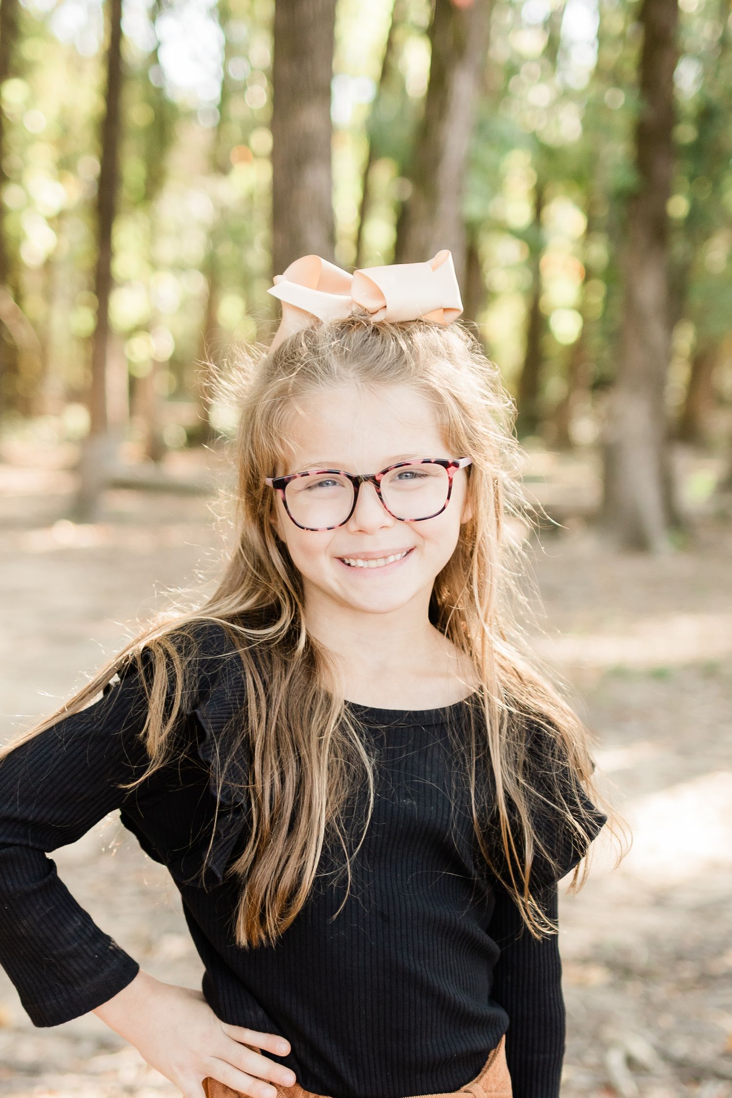 A series of outdoor portrait photos in a sunlit forest with natural bokeh lighting and black clothing.