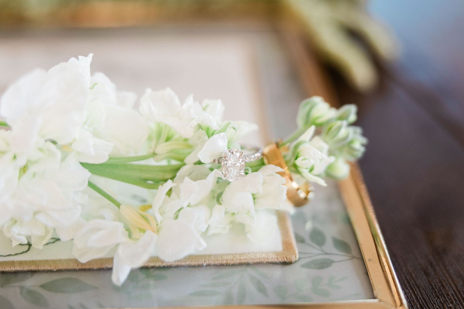 Fresh white paperwhites flowers arranged with bamboo chopsticks on a rustic wooden surface.