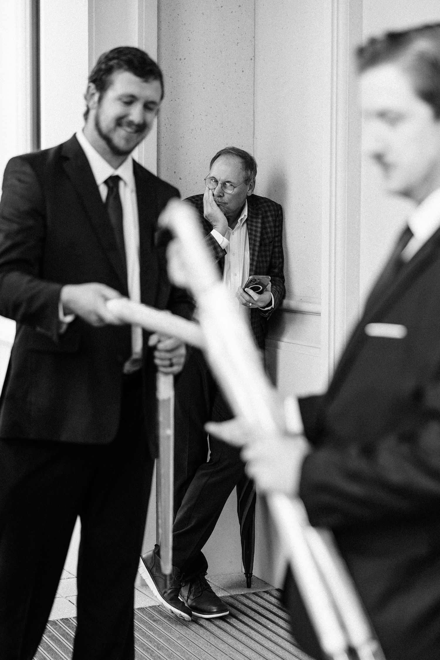 A black and white photo sequence showing people in business suits interacting in a professional setting.