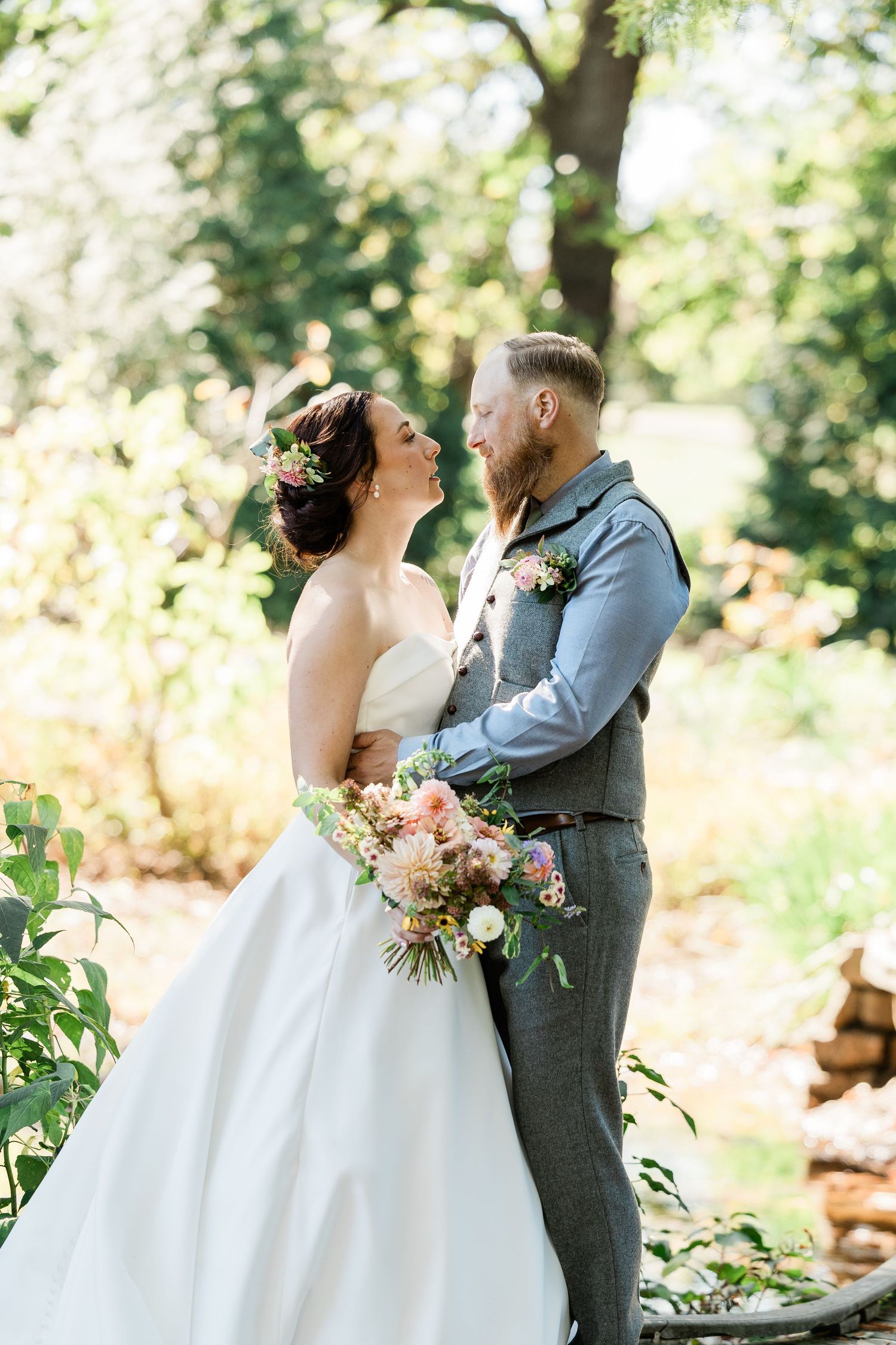 A romantic outdoor wedding scene shows a couple embracing in a sunlit garden setting with soft floral bouquets.