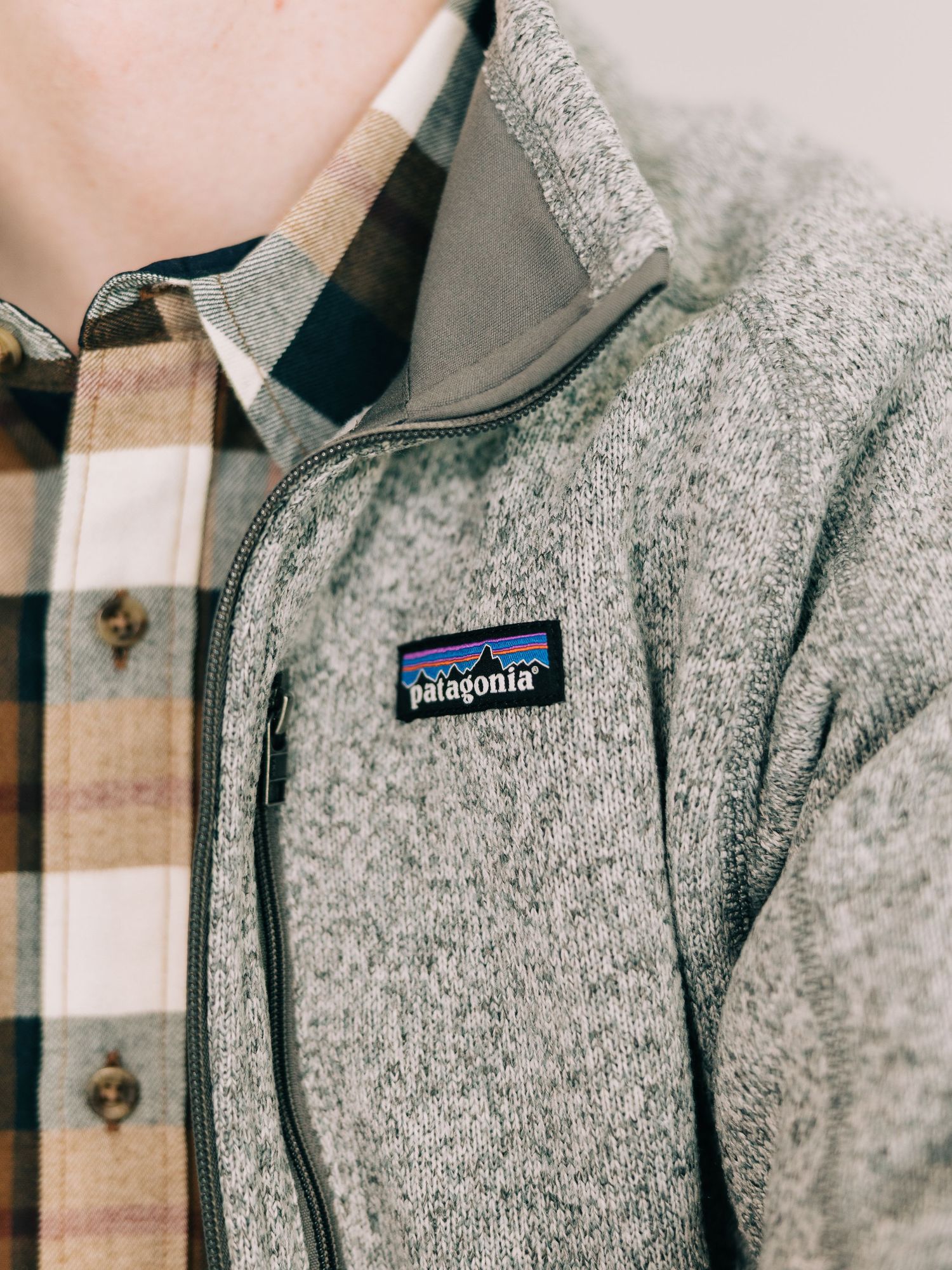 Close-up detail of a gray Patagonia fleece jacket showing texture and brand logo patch.