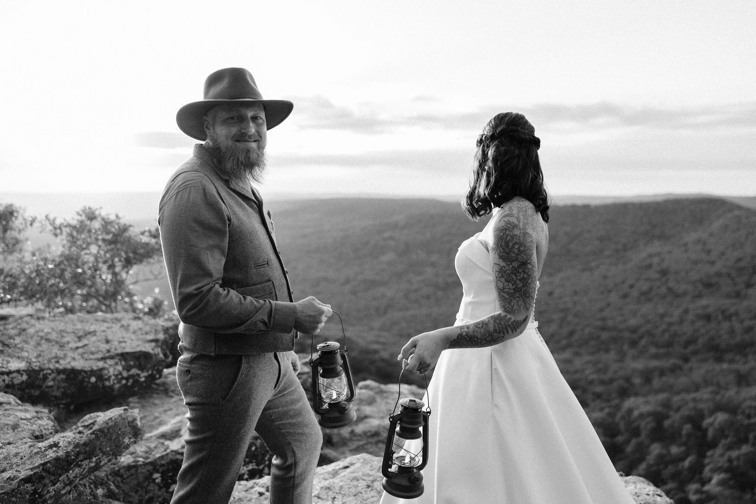 Wedding couple sharing emotional moment during outdoor mountain ceremony at sunset.
