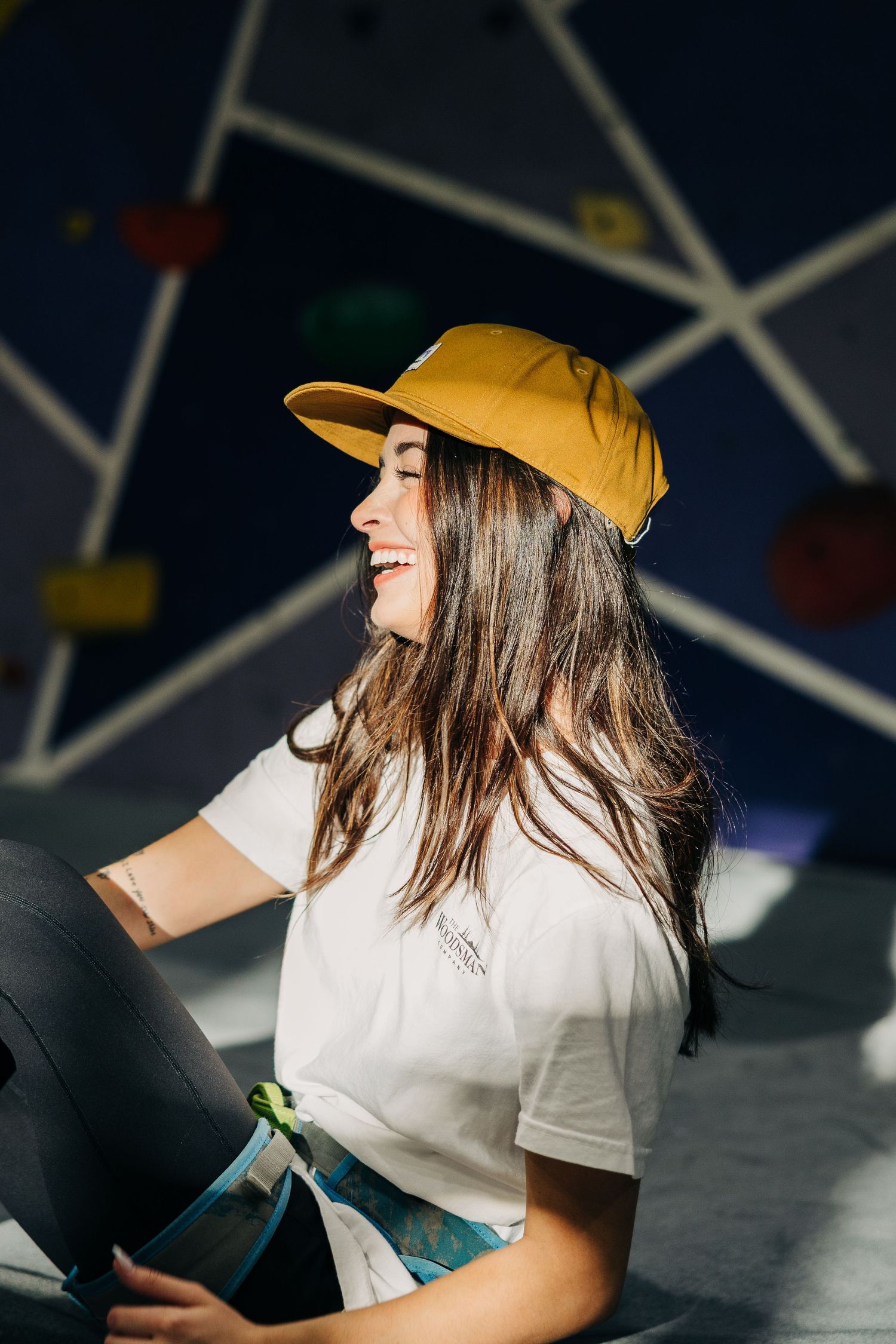 Person in yellow baseball cap and white t-shirt smiling and looking up in a series of profile shots.