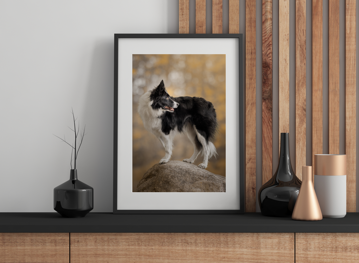 Modern shelf display with framed artwork, black vases, and copper accents against a wooden slat wall.