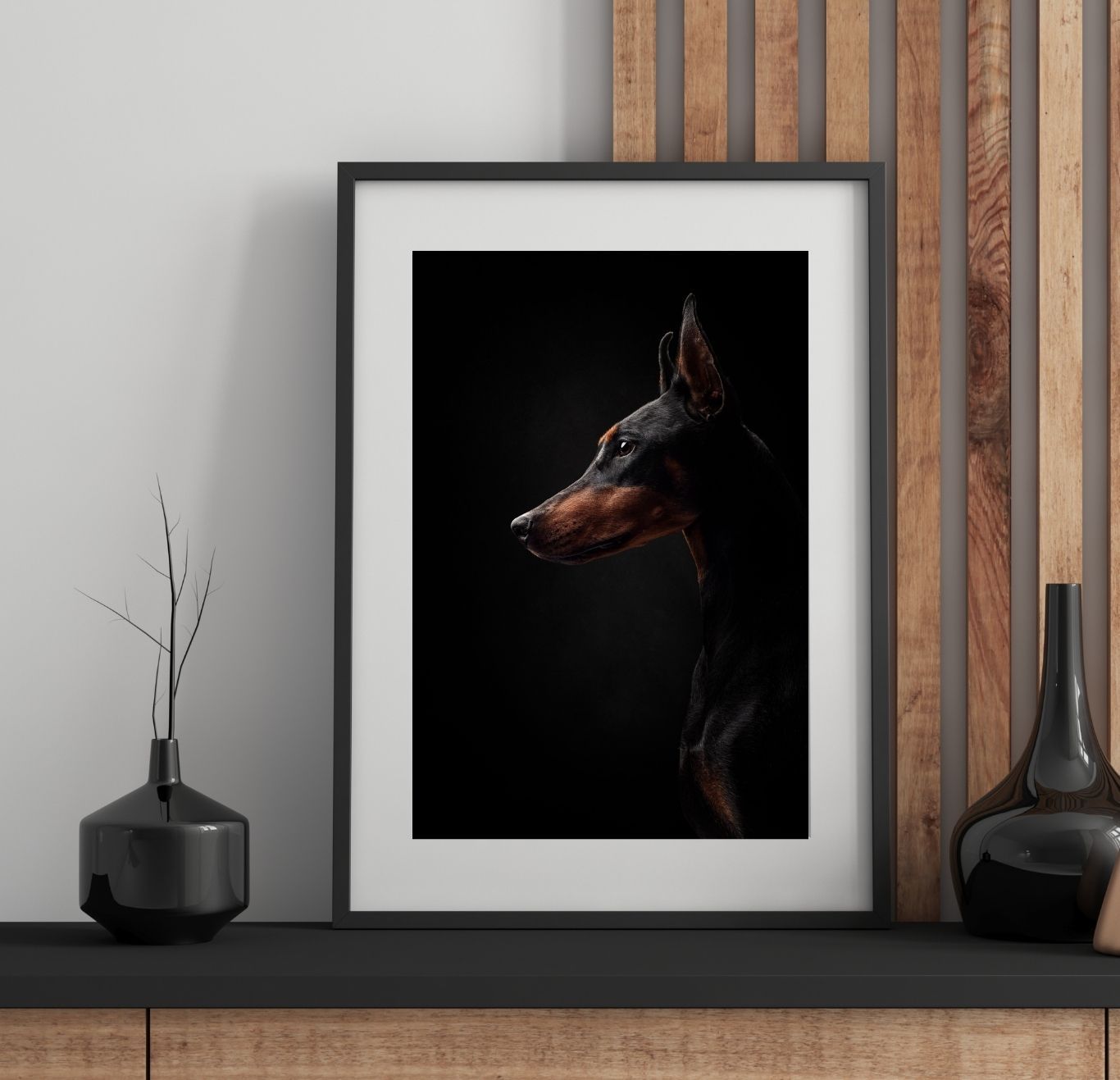 Minimalist black shelf display with vases and frames against a wooden slat wall creates modern aesthetic appeal.
