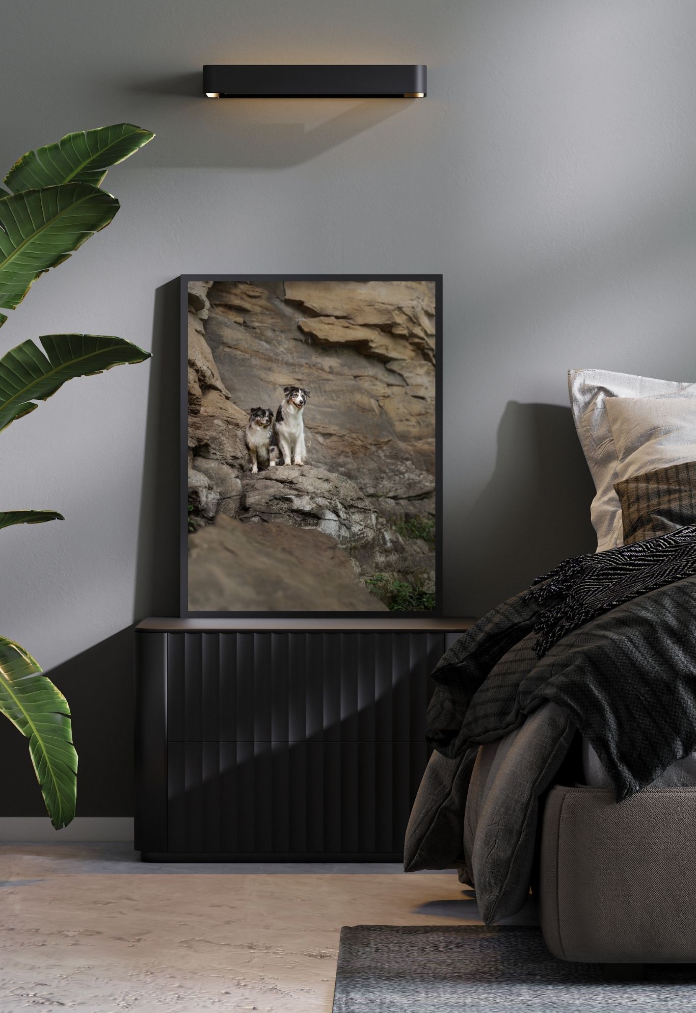 A modern living room setup with a mounted TV, dark sofa, and tropical plants against a gray wall.