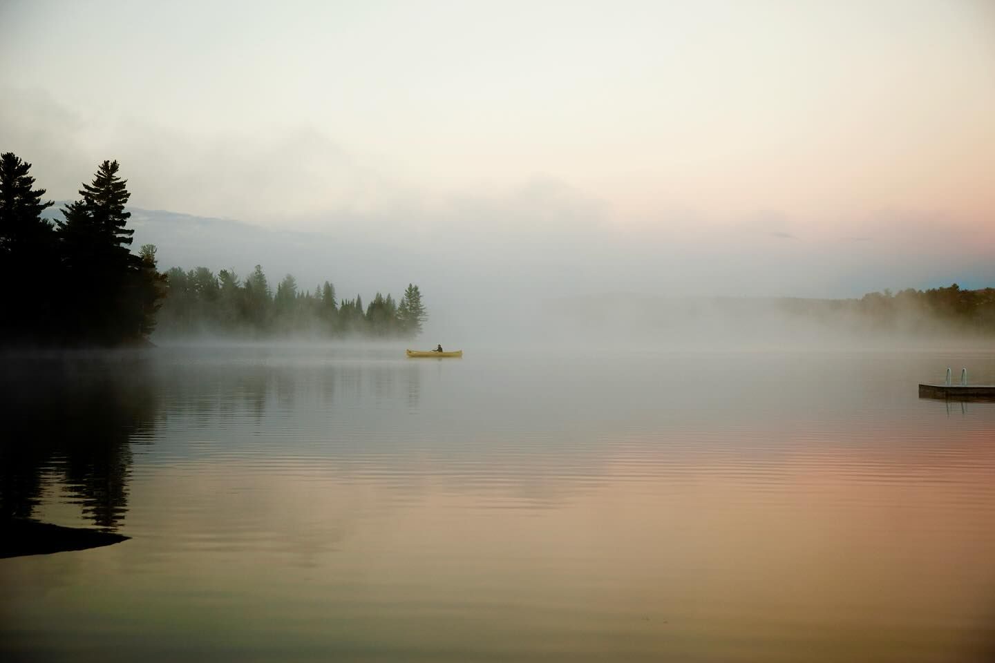 Person in a canoe on a misty lake