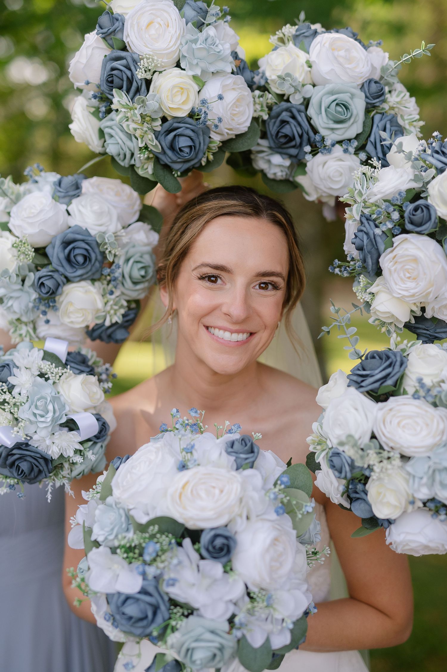 Beautiful wedding bouquet featuring white and dusty blue roses arranged in an elegant cascade style.