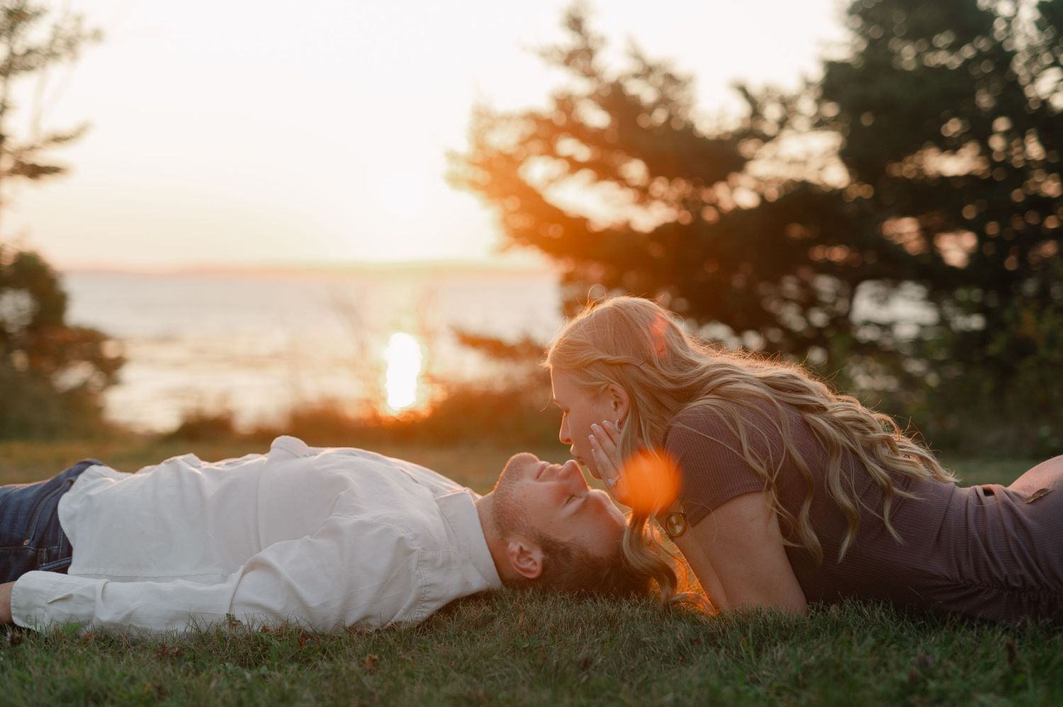 A romantic silhouette of two people against a vibrant sunset sky.
