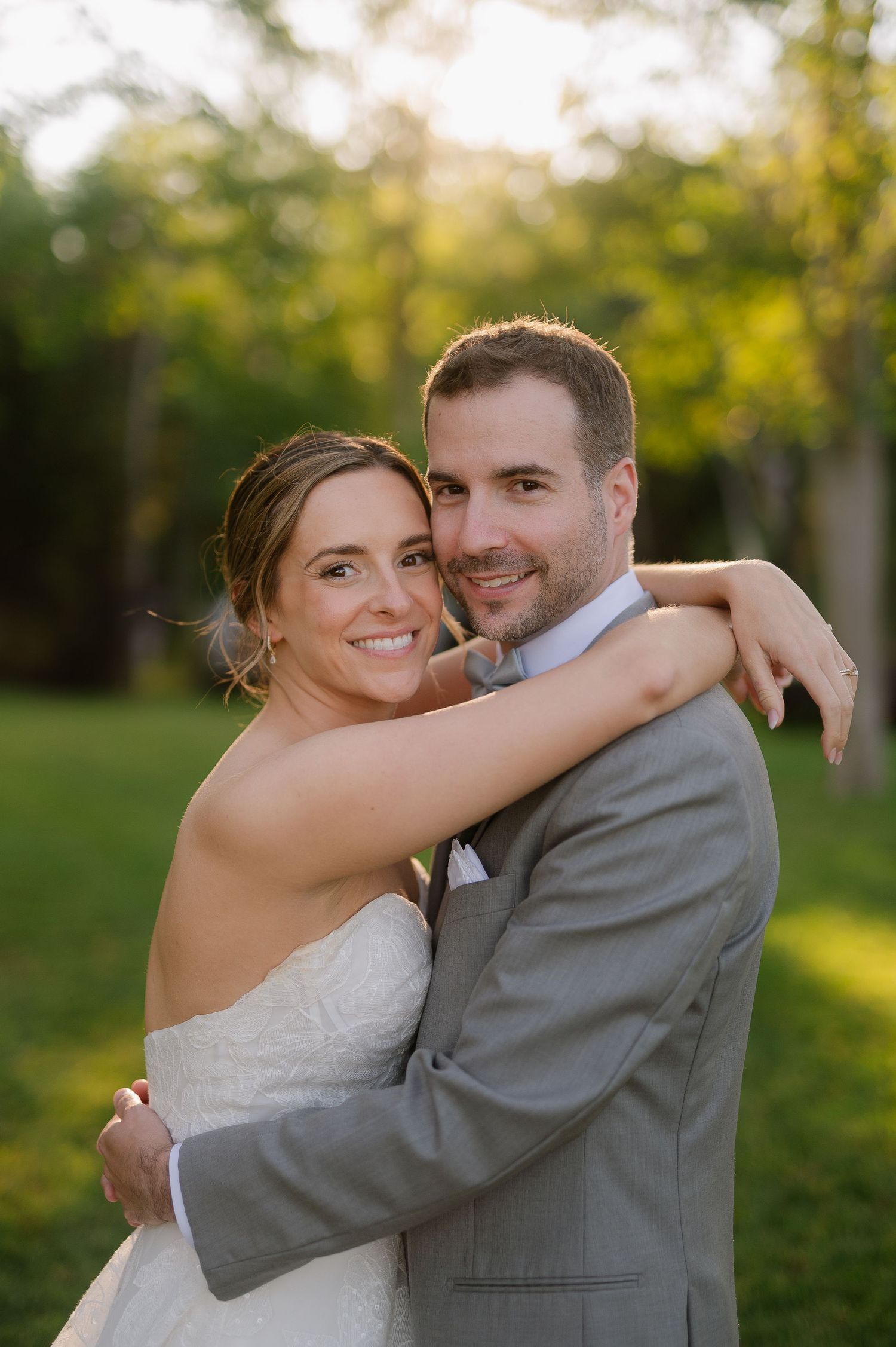 Romantic outdoor wedding portraits captured in warm evening sunlight.