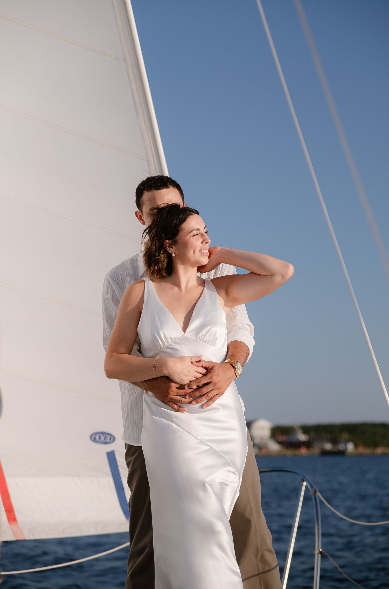 Candid moments of a couple enjoying a sunny afternoon on a sailboat deck.