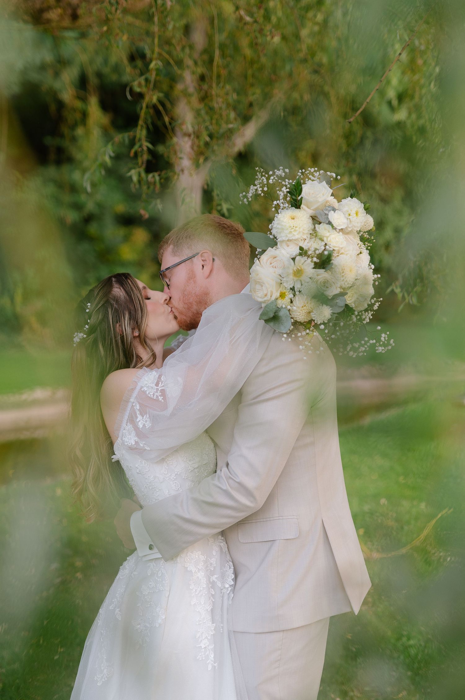 Romantic wedding portraits captured through willow tree branches.