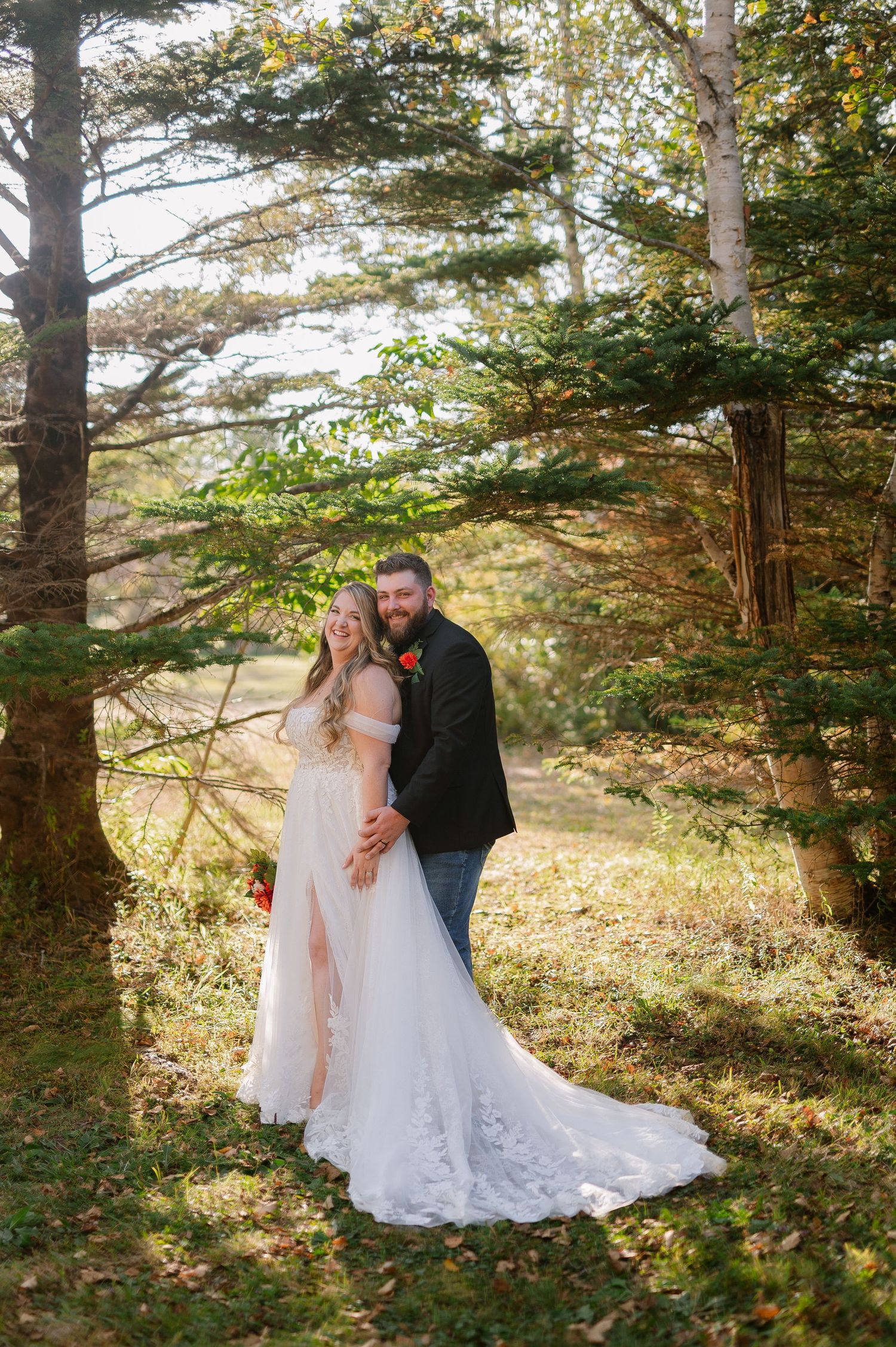 Romantic autumn wedding photos among evergreen trees with soft natural lighting.