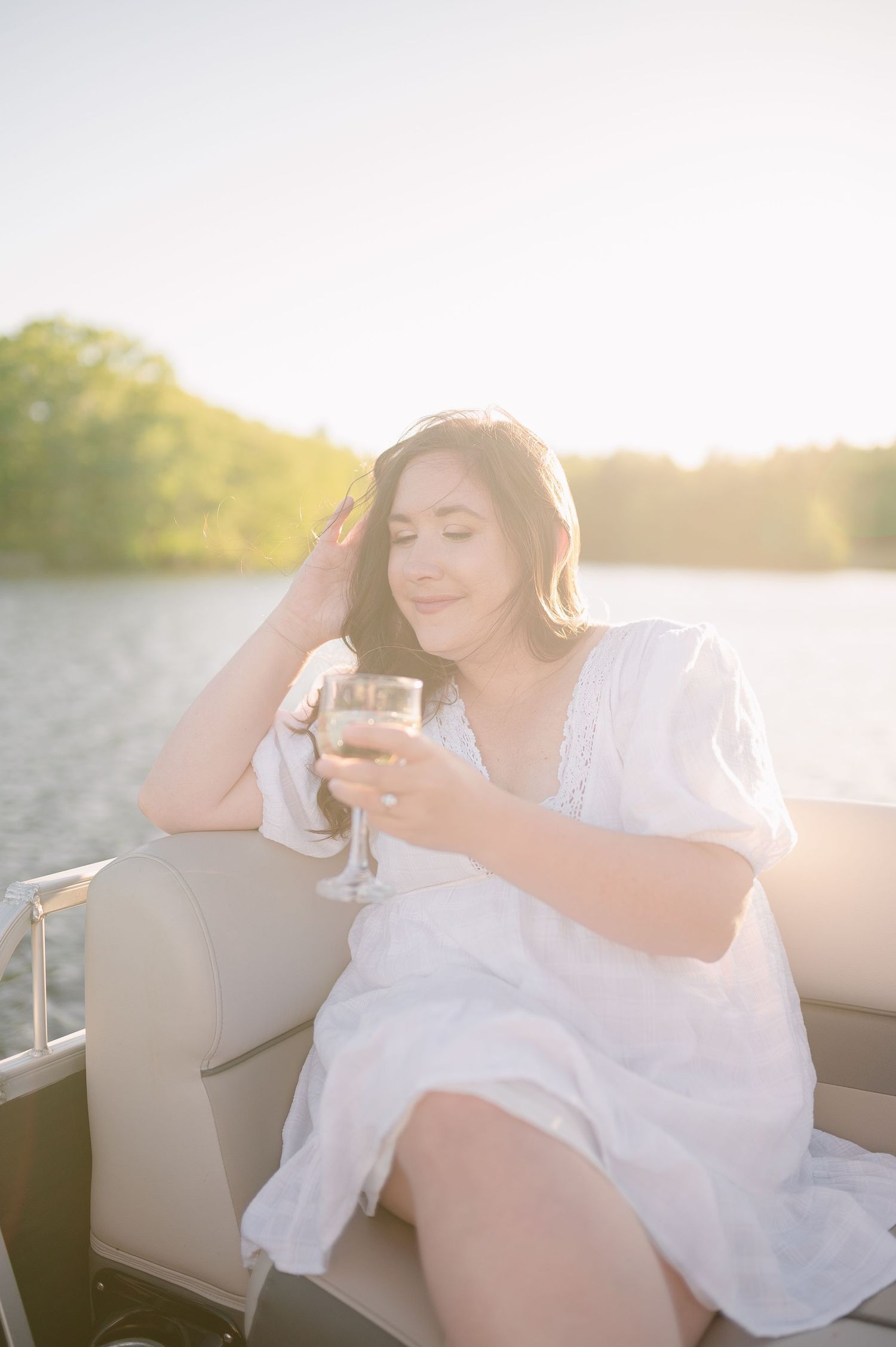 Couple relaxing together on a boat at sunset with golden light streaming across the water.