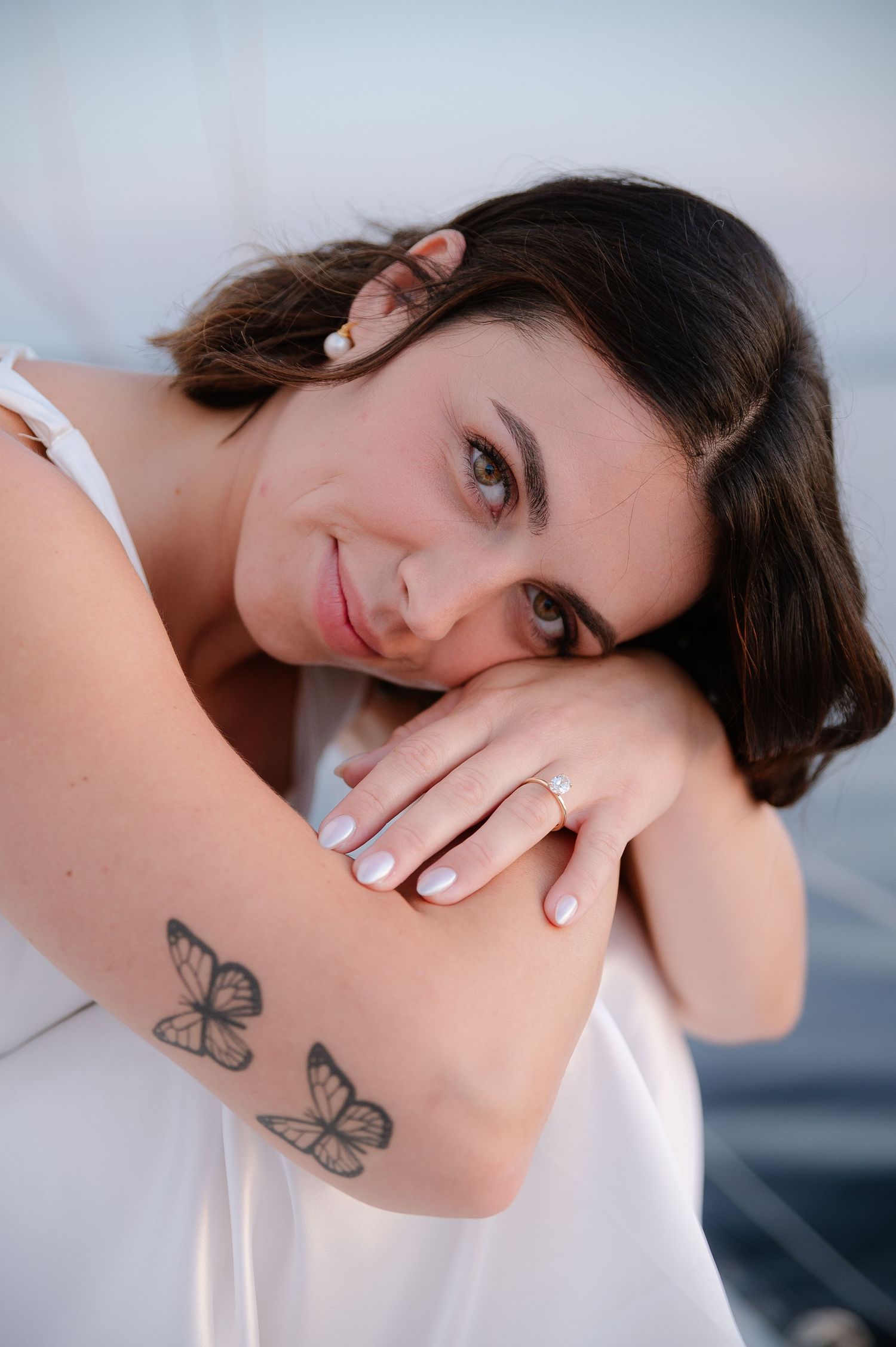 Close-up portrait series showing a butterfly tattoo on someone's arm.