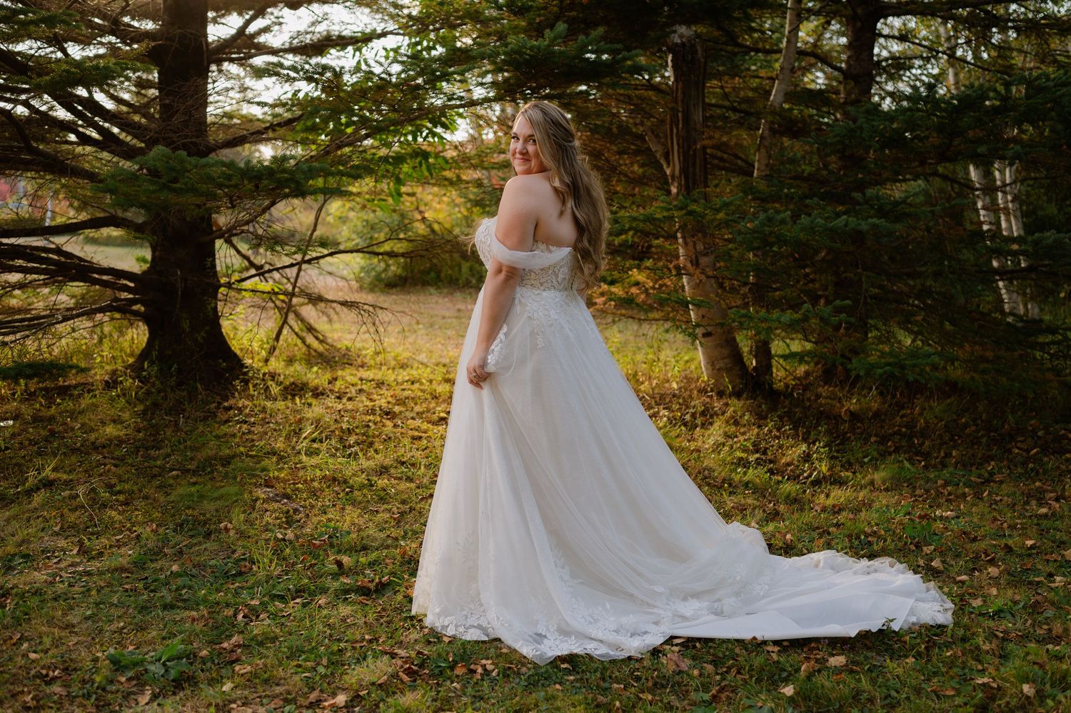 Elegant bridal portraits in a sunlit forest with flowing white gown.