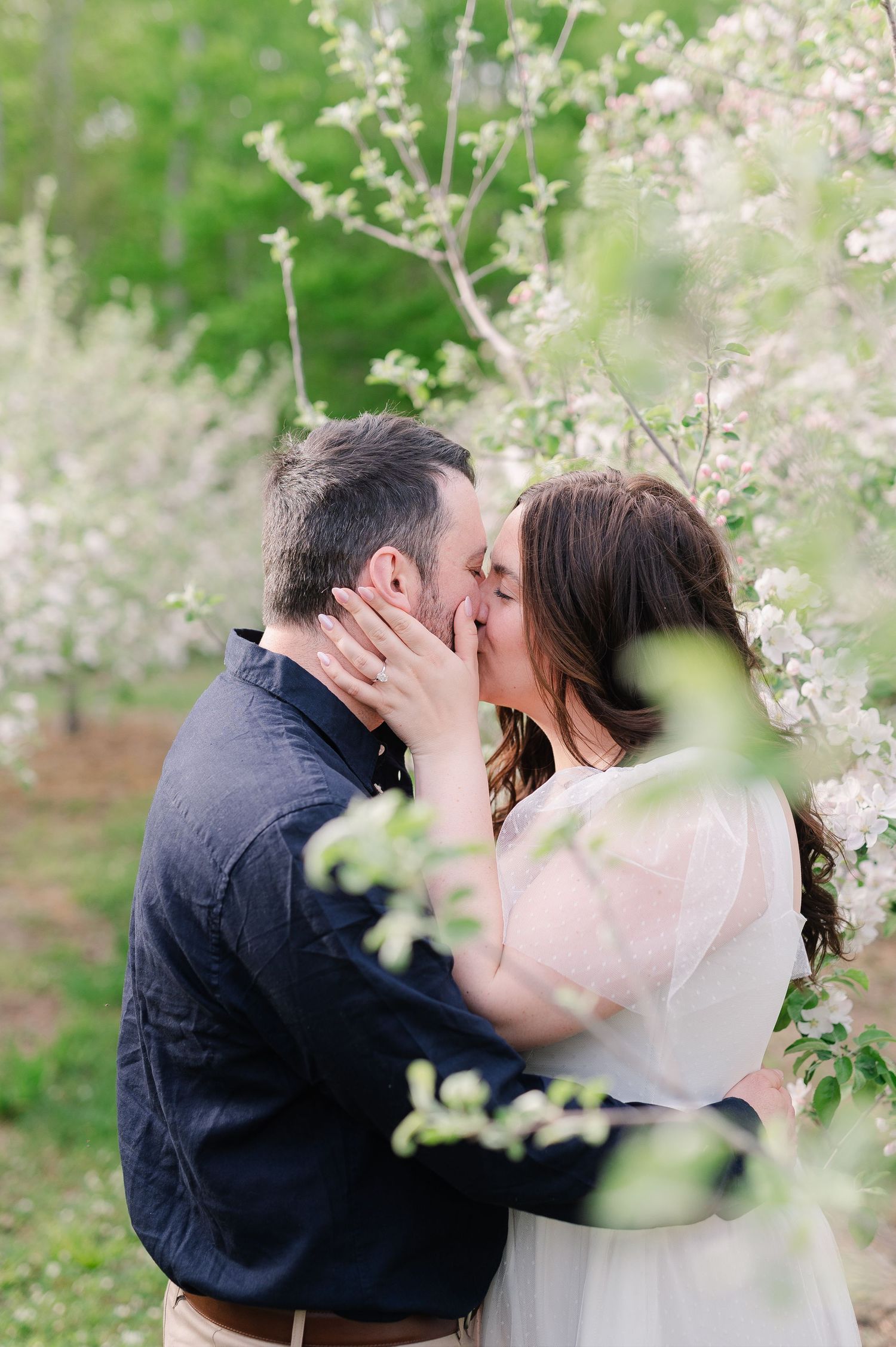 Romantic spring photo session with blossoming trees in soft focus.