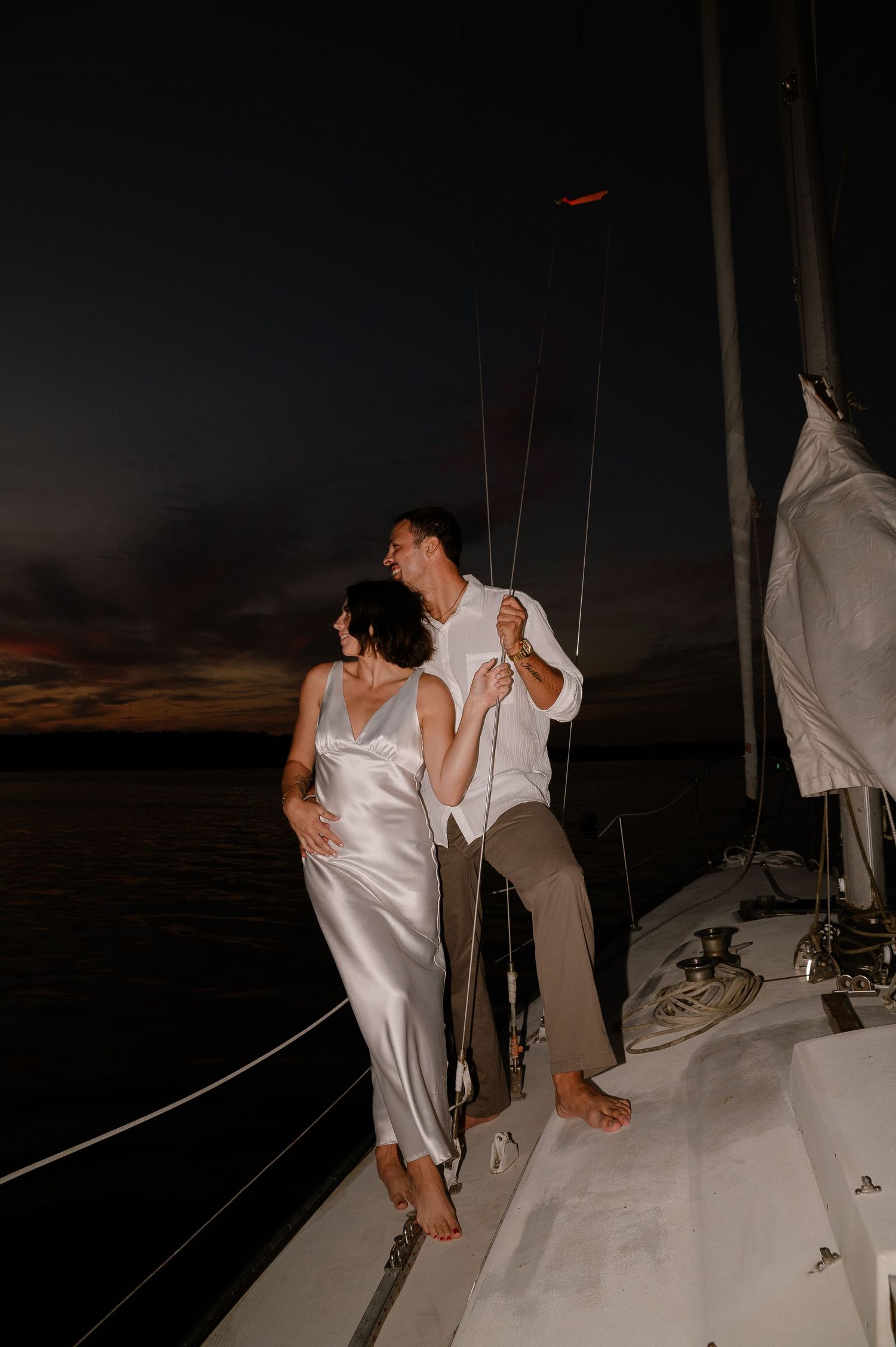 A nighttime photo sequence of a couple dancing on a boat deck under dark skies.