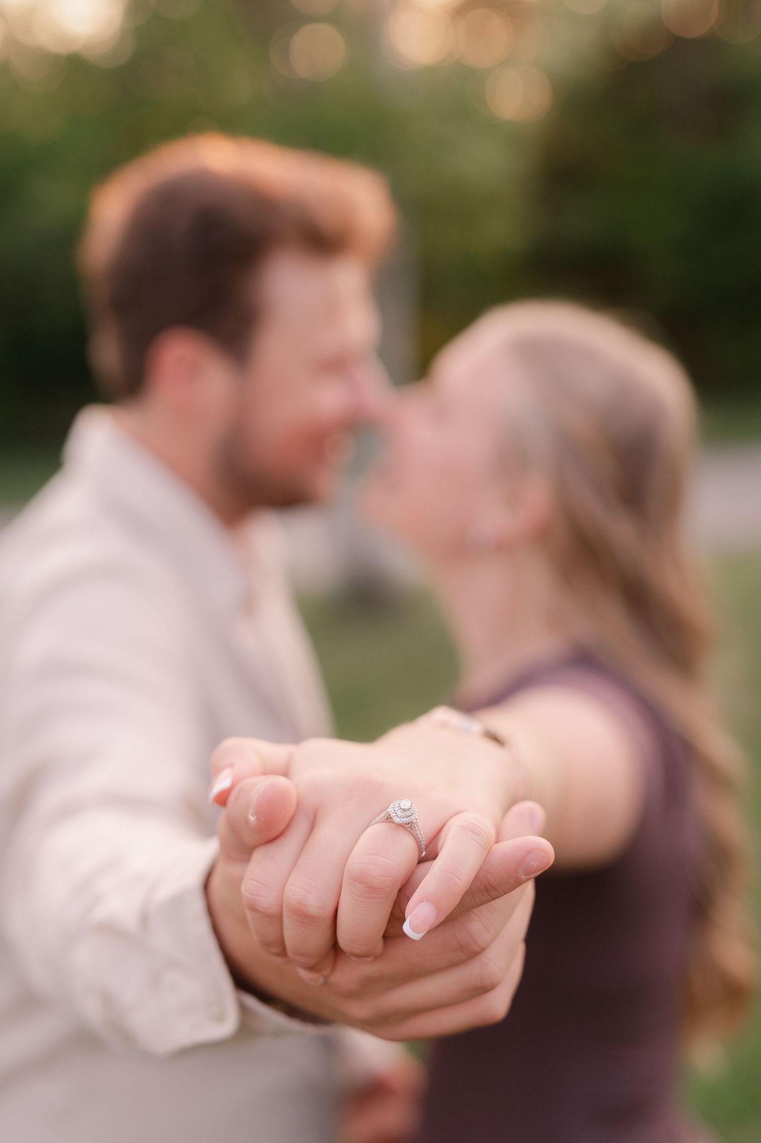 Close-up of hands dancing and intertwining against a sunset-lit background.