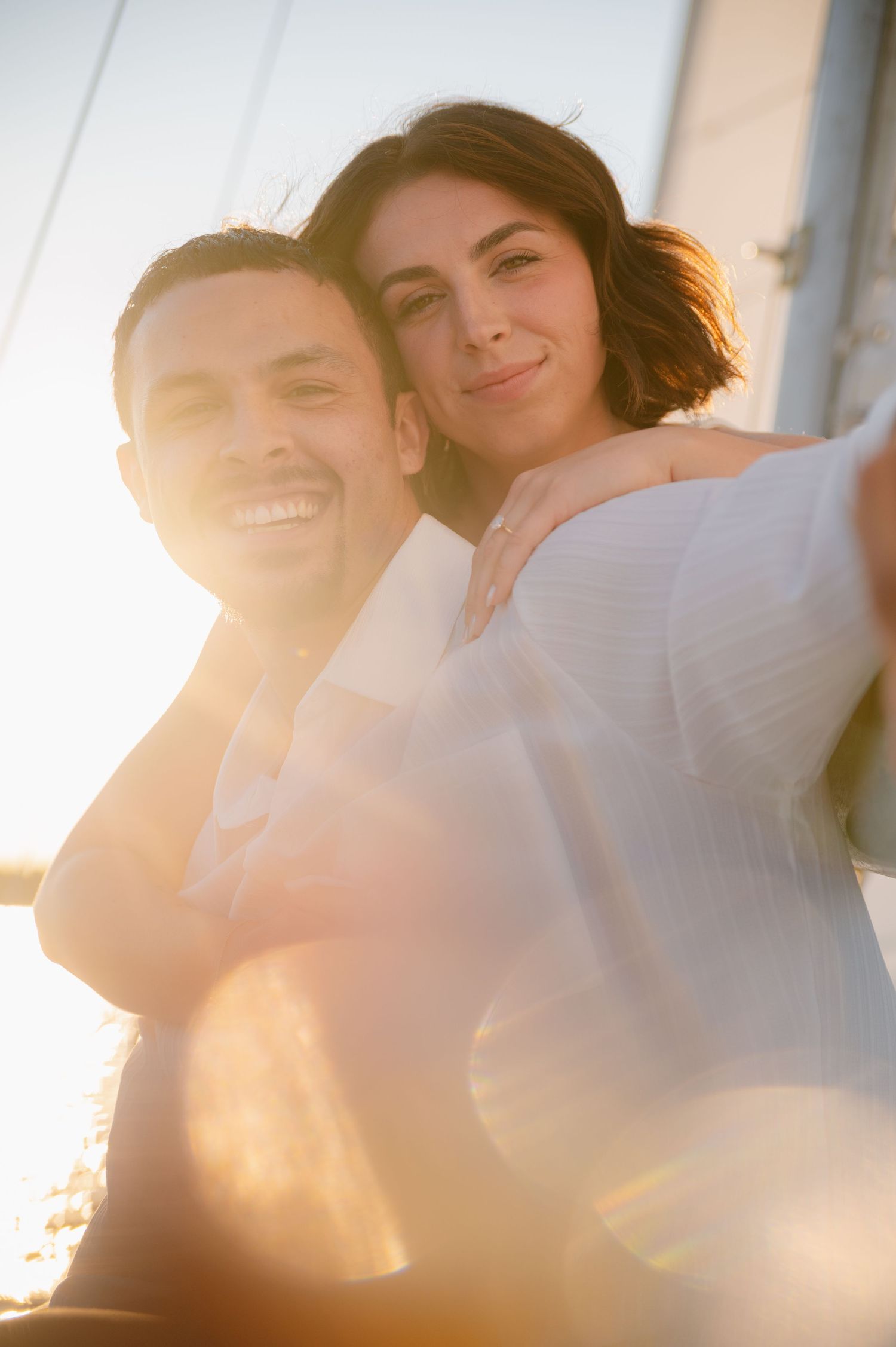 A romantic sunset photoshoot on a boat with warm golden light filtering through.