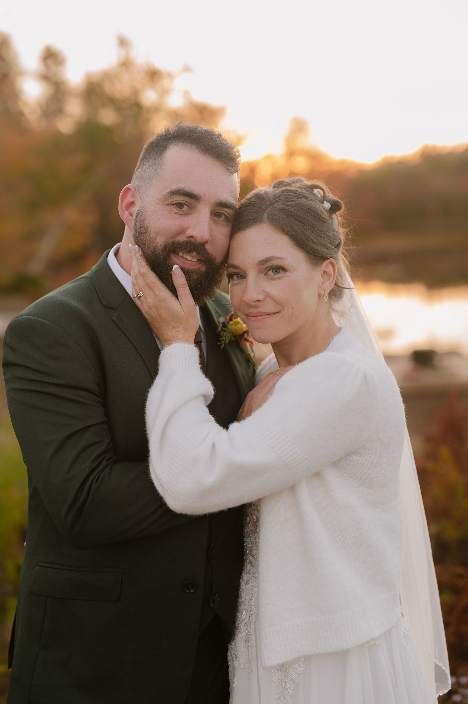Tender wedding moment captured during golden hour sunset.
