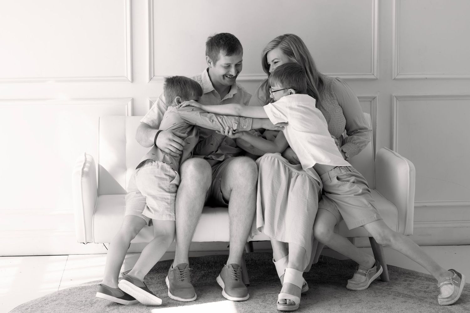 Family embracing and smiling in natural light, captured by local Sioux Falls family photography expert.